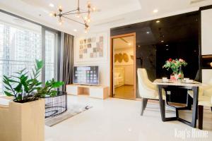 胡志明市Vinhomes Premium Apartment的客厅配有桌子和椅子