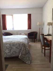 拉斯比拉斯比克洛酒店的卧室配有一张床和一张桌子及椅子