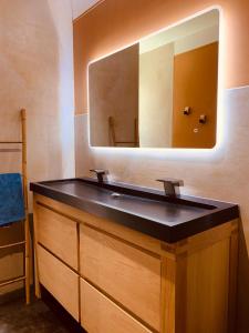 拉本讷Villa Dune & Océan的浴室设有黑色水槽和镜子