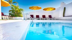 大加那利岛拉斯帕尔马斯Bull Astoria的一个带两把遮阳伞和椅子的游泳池