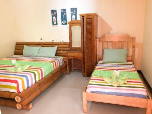 邦劳Ging Ging Homes Alona Beach的一间卧室配有两张床和镜子