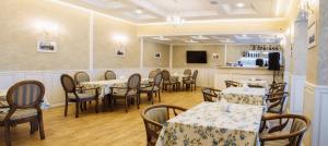 LubnyОтельно-ресторанный комплекс Златогор的一间带桌椅和电视的用餐室