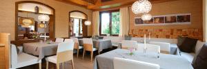 AlthütteGasthof Birkenhof的餐厅设有白色的桌子、白色的椅子和吊灯
