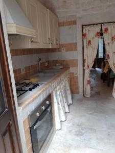 阿尔贝罗贝洛Alberobello Casa Vacanze - Pathos tra i Trulli的厨房配有炉灶和水槽。