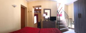 梅纳焦阿德勒酒店的一间卧室设有红色的床和楼梯。