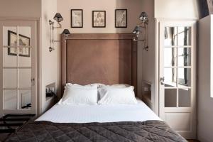 巴黎Hôtel Le Presbytère的卧室配有带白色枕头的大床