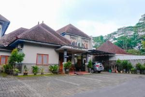 玛琅OYO 778 Guest House Amalia Malang的停车场内有停车位的建筑物