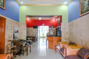玛琅OYO 778 Guest House Amalia Malang的客厅拥有色彩缤纷的墙壁和沙发