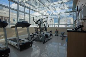 库里提巴Hotel Centro Europeu的带有氧器材的健身房,位于带窗户的房间内