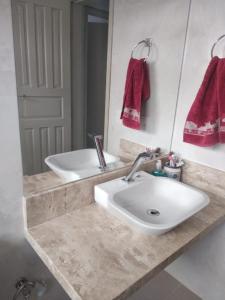 维多利亚Recanto da Vovó com Bike的浴室设有白色水槽和镜子
