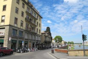 佛罗伦萨Renovated Central Suites的停在大楼前的一条有摩托车的街道