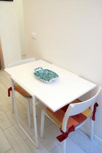 佛罗伦萨Renovated Central Suites的一张白色的桌子和椅子,上面有盘子