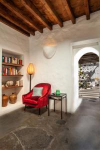 蒂亚斯Los Lirios Hotel Rural - Adults Only的一张红色椅子坐在带桌子的房间