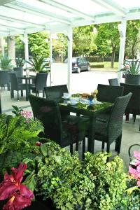 里米尼Hotel Vernel的庭院配有桌椅和鲜花