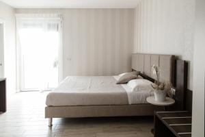 拉齐塞Menta e Rosmarino Rooms的白色卧室配有一张大床和一张桌子