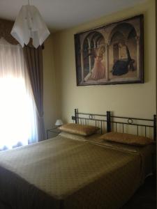 威尼斯艺术家旅馆的卧室配有一张床,墙上挂有绘画作品