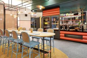 雅加达ibis Styles Jakarta Tanah Abang的一间带桌椅的餐厅和酒吧