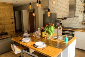 夏蒙尼-勃朗峰Apartment Maya, La Praz, Chamonix Mont Blanc的厨房配有木桌和水槽。