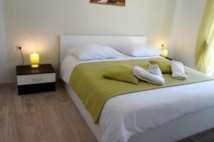 拉布Apartments Kampor的一间卧室配有一张带两个枕头的床