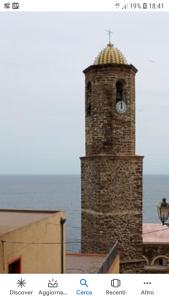 卡斯特尔萨多L'Antico Faro的一座高大的砖塔,上面有钟