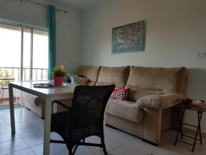 阿亚蒙特Aloja Puerto Deportivo的客厅配有沙发和桌子