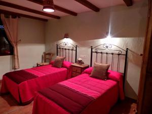 布伦切尔Alojamiento Rural Marina的配有粉红色床单的客房内的两张床