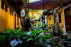 瓦哈卡市Hotel Dainzu的一个带遮阳伞、椅子和植物的庭院
