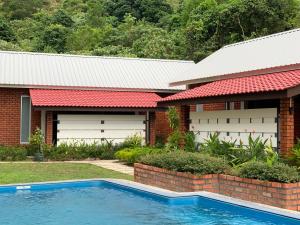珍南海滩Hujung Kampung Estate的一座房子前面设有游泳池