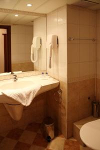 阳光海滩Hotel Yunona - All Inclusive的一间带水槽、卫生间和镜子的浴室