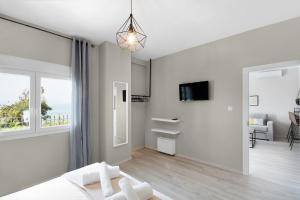 尼亚伊拉克利亚Villa Alexandra的白色的卧室设有床和大窗户