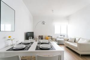塞维利亚TRIANA 3 Bedrooms & 2 bath Parking Included的白色的客厅配有桌子和沙发