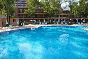 阳光海滩Hotel Yunona - All Inclusive的一个带椅子和遮阳伞的大型蓝色游泳池