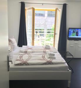 柏林新格林公寓式酒店的一间卧室设有一张带电视和窗户的床。