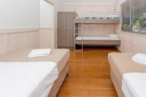 萨维特尔比格4索特尔海滩假日公园的客房设有两张床和一张双层床。