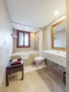 河内La Dolce Vita Hotel的浴室配有盥洗池、卫生间和镜子。