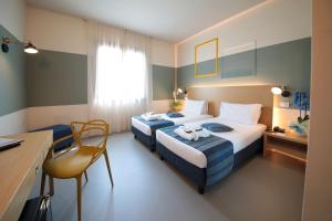 维尔吉利奥Best Western Hotel Cristallo Mantova的酒店客房配有两张床和一张书桌