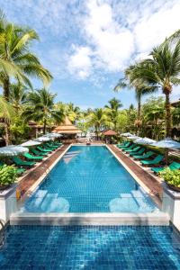 蔻立考拉克海湾度假酒店的一个带躺椅的游泳池,棕榈树