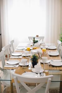 塞维利亚Stylish and wide- 3Bdr 3Bth- Los Remedios的餐桌,配有白色的盘子和椅子