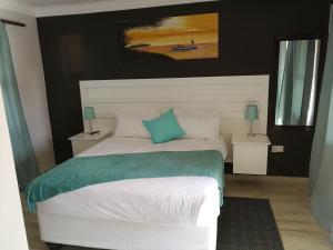 帕拉佩Double L Guest Lodge Palapye的卧室配有白色床和蓝色枕头