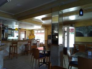 希奥Hospedaje O Canizo的一间带桌椅的餐厅和一间酒吧