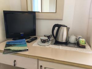 阿列恩图索尔根特酒店的一张桌子、一台电视、一个咖啡壶和一本书