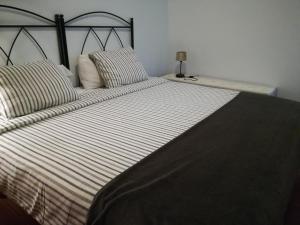 法马拉El Charquito的一张带条纹床单和枕头的大床