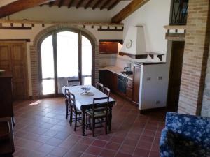 科尔萨诺Agriturismo Fattoria Di Corsano的厨房以及带桌椅的用餐室。