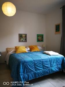 比萨Villa Galilei Rooms的一间卧室配有一张带蓝色棉被和黄色枕头的床。