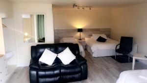 卡林福德Wildwood Lodge的酒店客房配有一张床和一张皮沙发