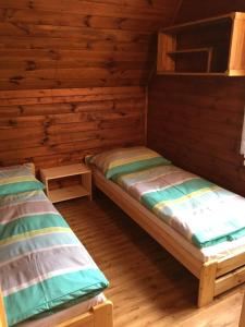 多克西Chata Pod Bílým kamenem的小屋设有两张木墙床