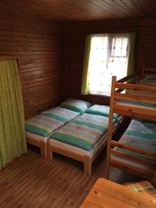 多克西Chata Pod Bílým kamenem的一间卧室设有两张双层床和一扇窗户。