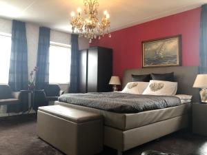阿尔滕B&B nancy in holland的一间卧室设有红色的墙壁和一张带吊灯的床。