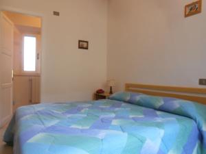 奥尔贝泰洛PENSIONE VERDE LUNA的一间卧室配有一张带蓝色棉被的床