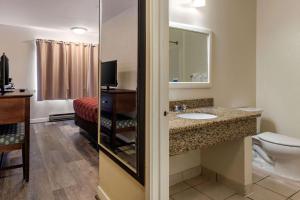 滨海城Bay Breeze Inn的客房内设有带水槽和卫生间的浴室